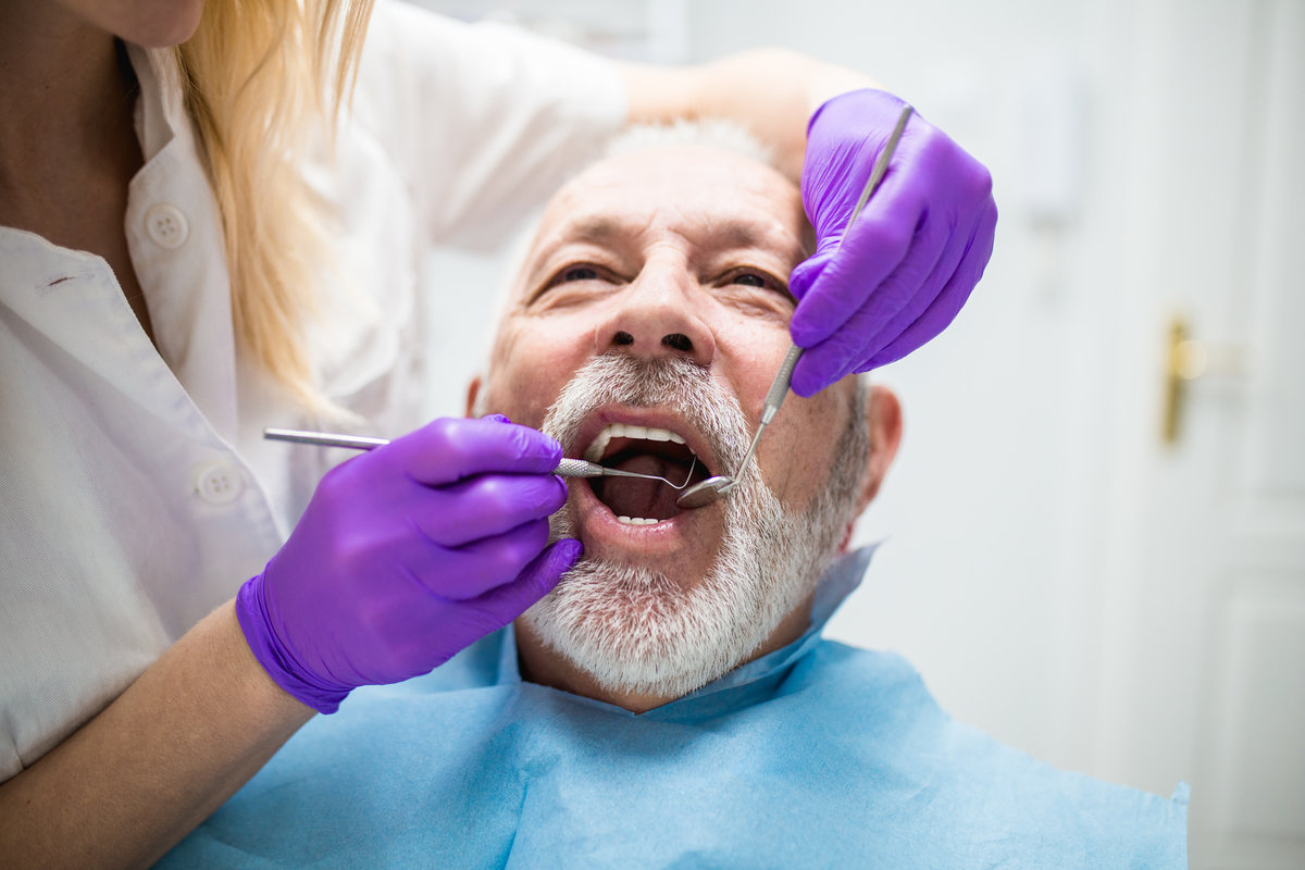 Senior man having dental treatment at dentist's office.