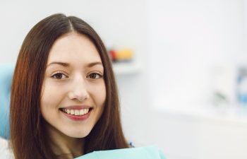 Beautiful patient sits in a chair at the dentist