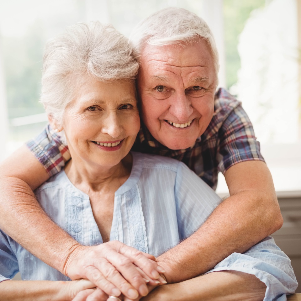 Portrait of senior couple embracing at home