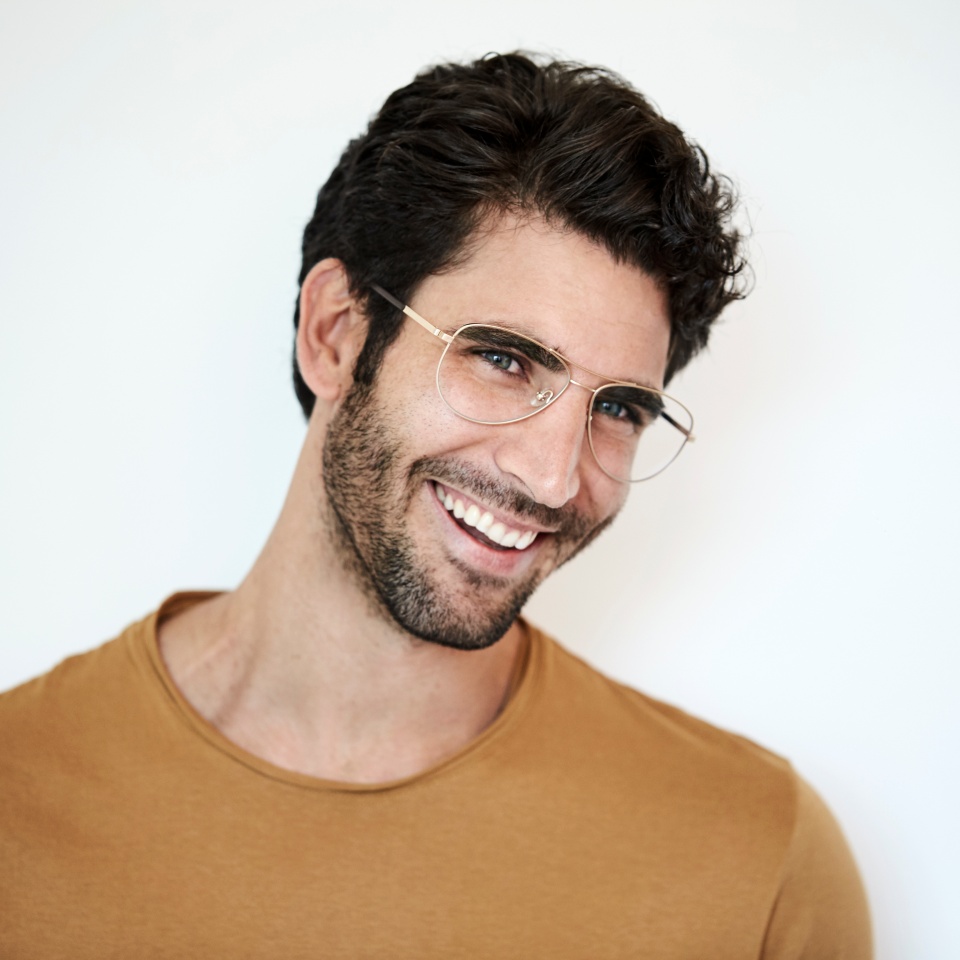 Guy in glasses smiling against white background
