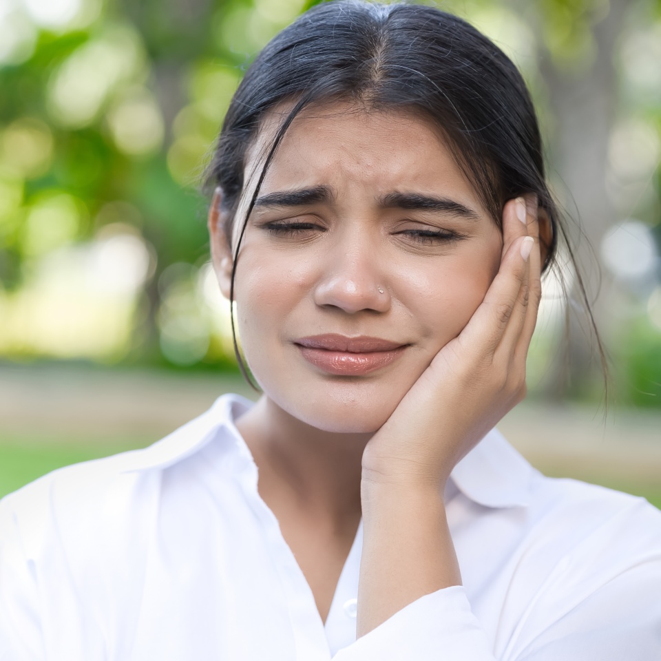 South Asian, Indian woman suffering from toothache, tooth decay, tooth sensitivity, wisdom tooth pain, cavity, dental care concept, outdoor background