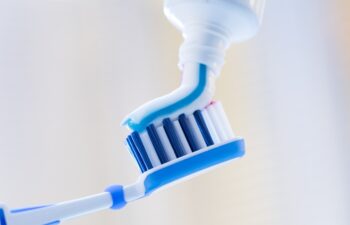 Closeup of a toothbrush and toothpaste on blurred background