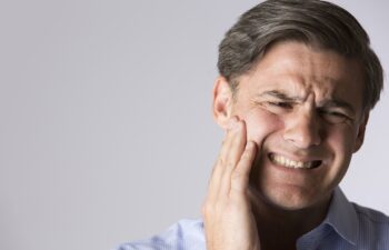 Studio Portrait Of Man Suffering With Toothache