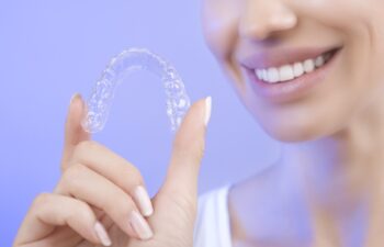 Beautiful Smiling Girl with Tooth Tray (hands Holding Individual Tooth Tray) Methods of Teeth Teeth Whitening and Correction Close-up (blue filter effect)