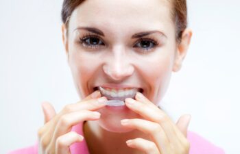 Teeth whitening woman with tooth tray on teeth
