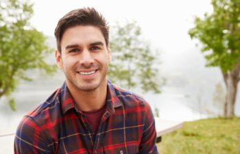 Young Hispanic man in a park smiling to camera, portrait