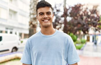 Young hispanic man smiling confident standing at street