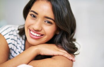Portrait, relax and girl on couch, comfort and home with happiness, calm and weekend break. Face, apartment and person on sofa, cheerful or peace with lounge, wellness and house with smile or woman